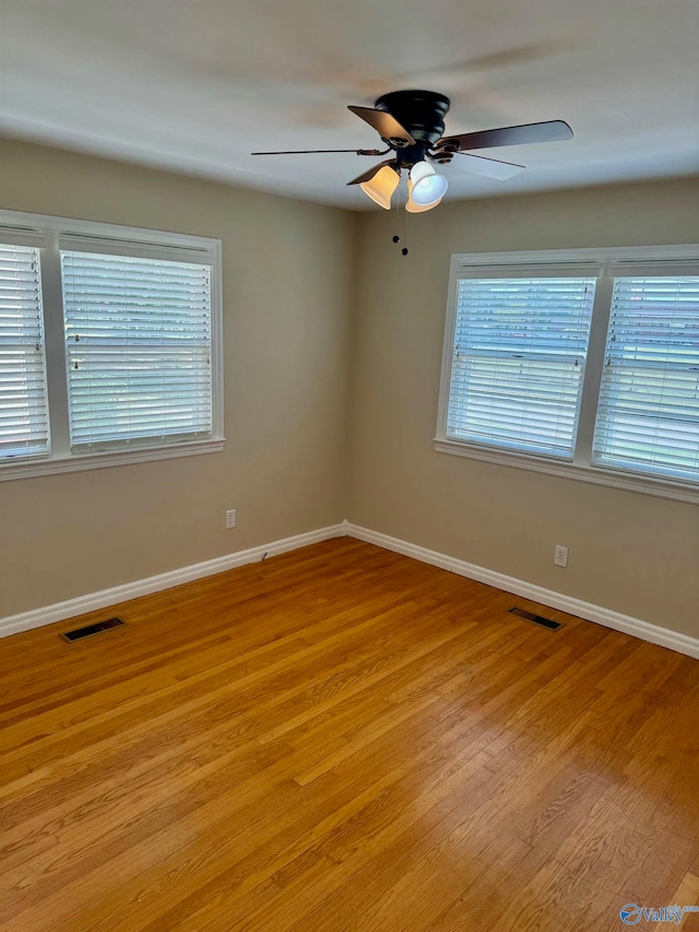 spare room with ceiling fan and light wood-type flooring