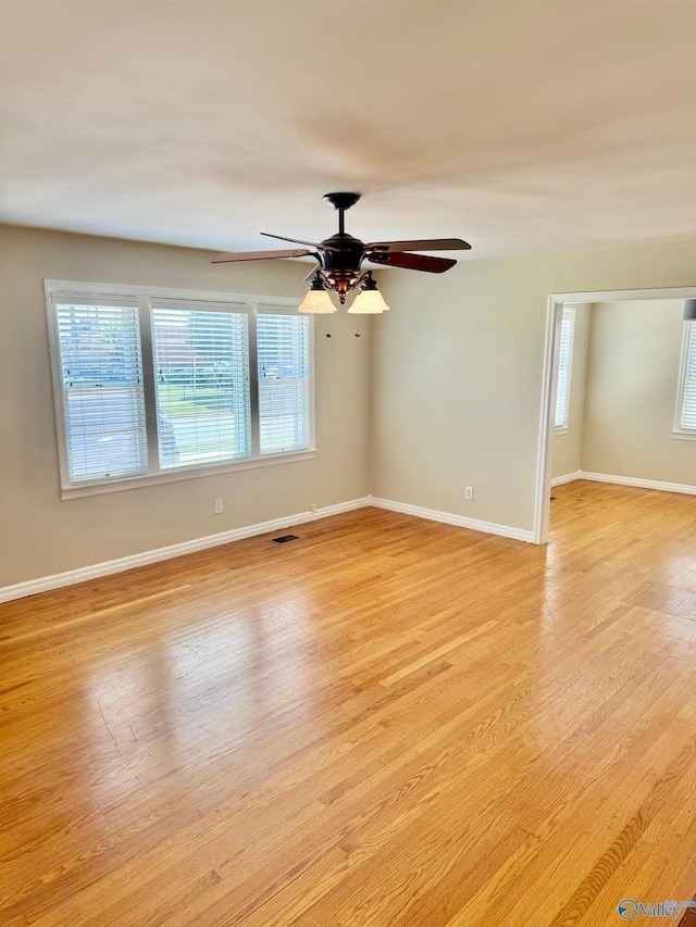 empty room featuring ceiling fan, light hardwood / wood-style floors, and a healthy amount of sunlight