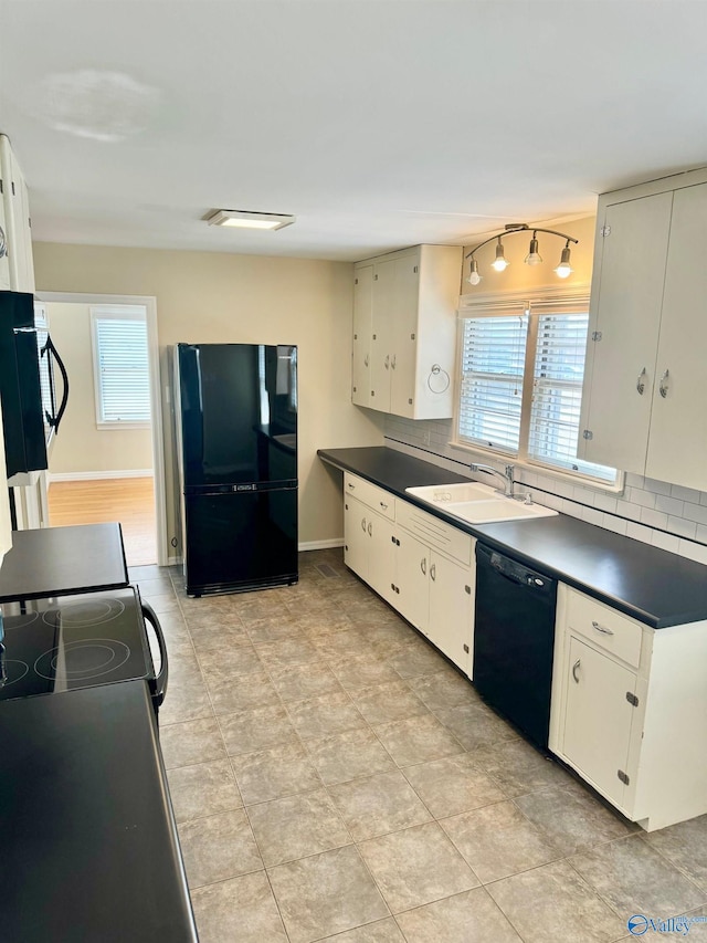 kitchen with sink, decorative backsplash, track lighting, light tile patterned floors, and black appliances