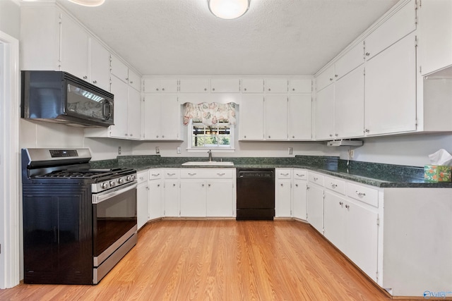 kitchen with white cabinets, a textured ceiling, black appliances, light hardwood / wood-style floors, and sink