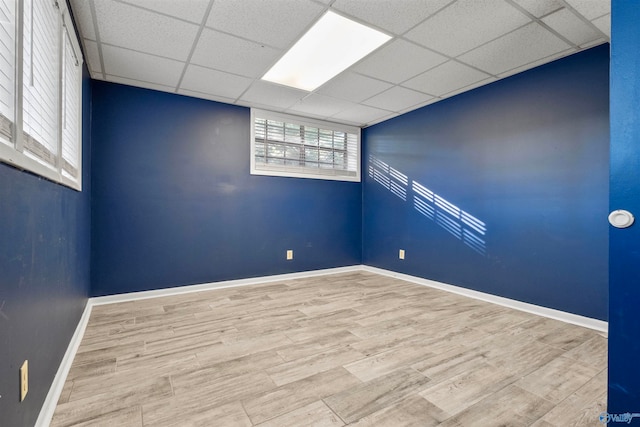 spare room with light hardwood / wood-style floors and a paneled ceiling