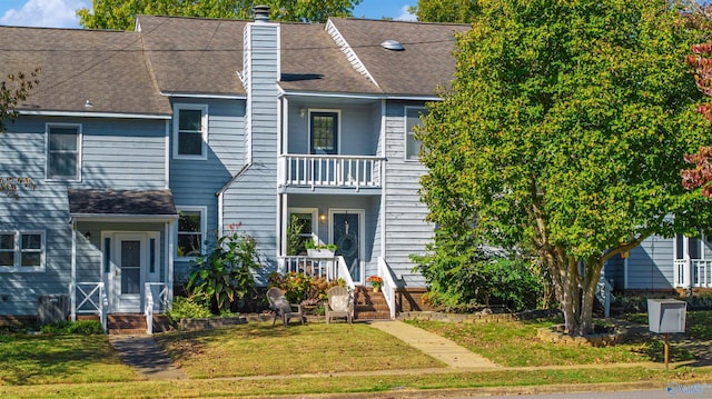 view of property featuring a front yard and a balcony