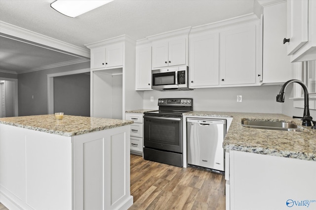 kitchen featuring light hardwood / wood-style floors, a center island, stainless steel appliances, sink, and white cabinets