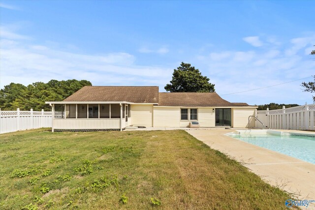 back of house with a sunroom and a lawn