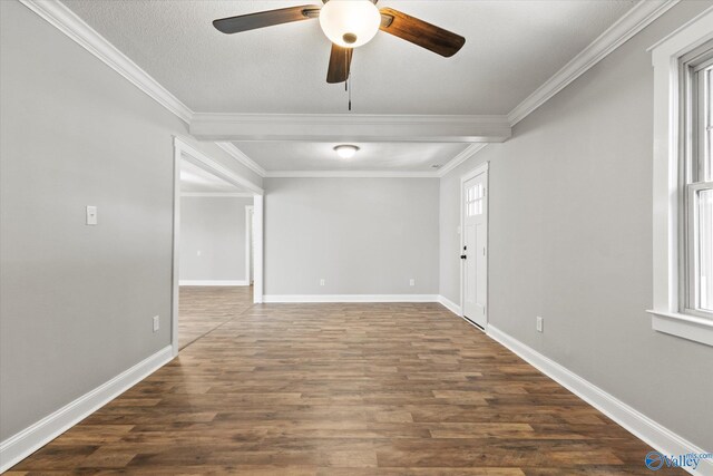 empty room with a textured ceiling, ornamental molding, and dark hardwood / wood-style flooring