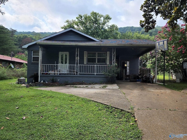 view of front of property featuring an attached carport, a front yard, a porch, and driveway