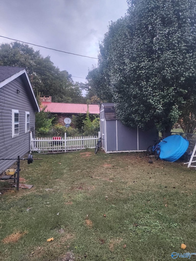 view of yard featuring an outdoor structure, a storage unit, and fence