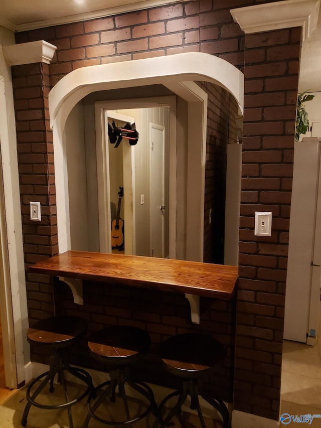 bar with a dry bar, arched walkways, and brick wall