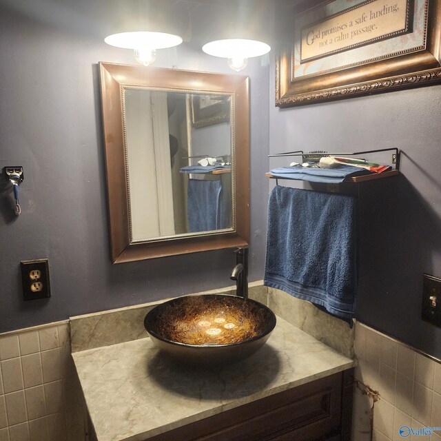 bathroom featuring wainscoting, tile walls, and vanity