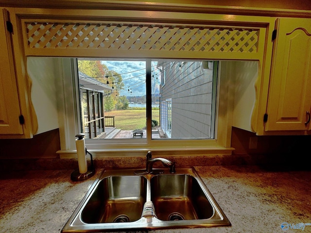 interior details featuring light stone countertops and sink