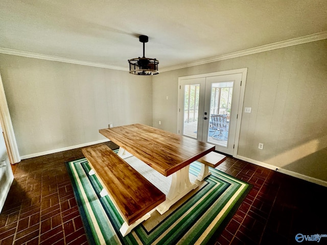 unfurnished dining area featuring an inviting chandelier, crown molding, and french doors