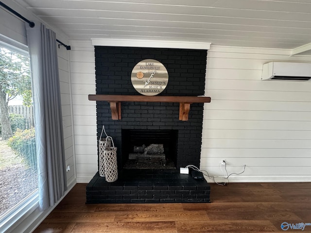 interior details featuring hardwood / wood-style floors, a wall unit AC, and a fireplace