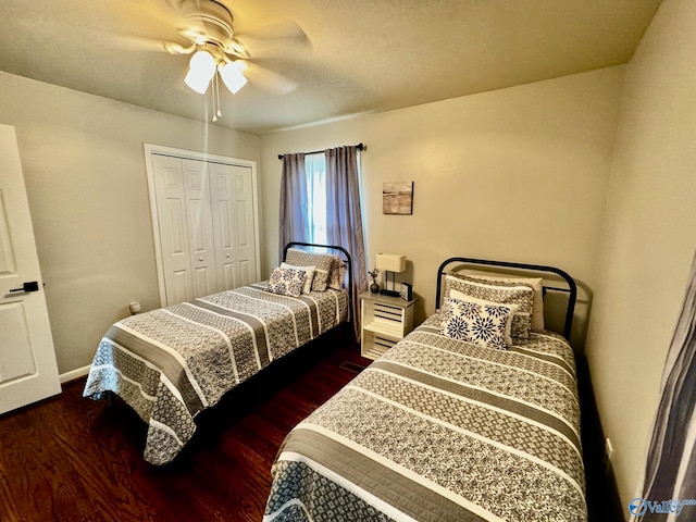 bedroom with ceiling fan, a closet, dark hardwood / wood-style floors, and a textured ceiling