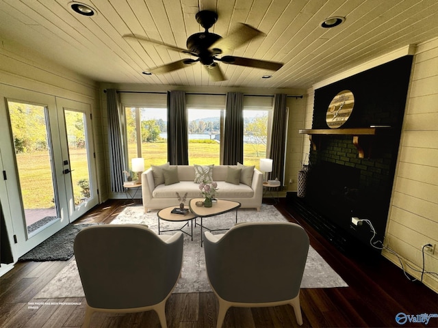 living room with wood ceiling, dark hardwood / wood-style flooring, and a brick fireplace