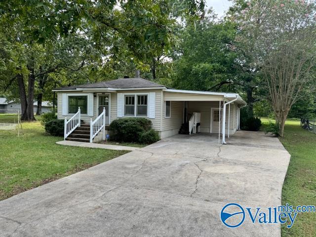 view of front of home featuring a carport, concrete driveway, and a front lawn