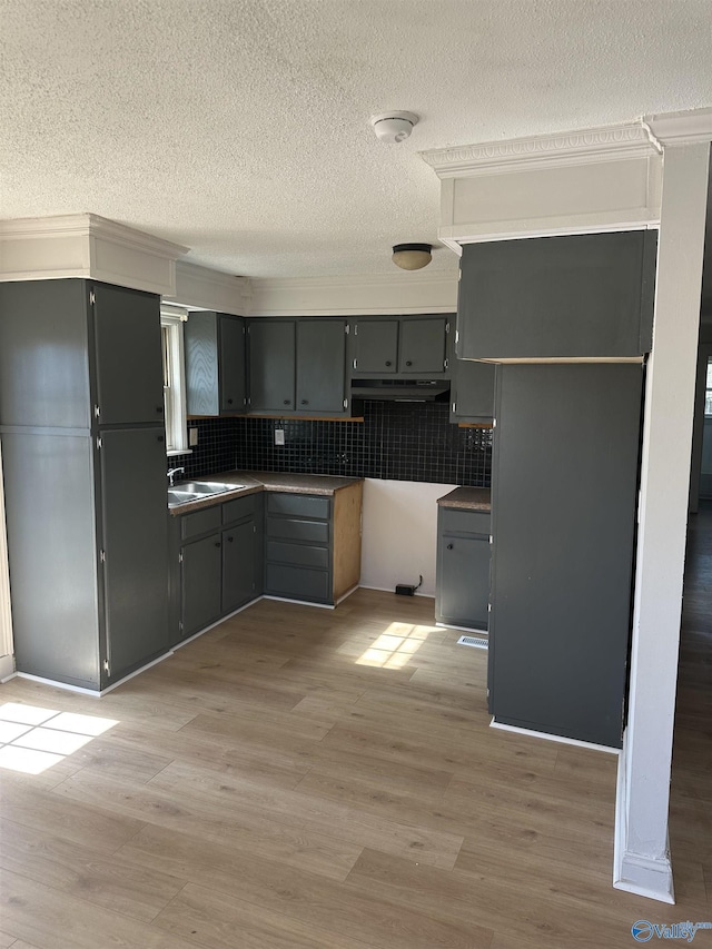 kitchen with decorative backsplash, gray cabinets, and light hardwood / wood-style floors