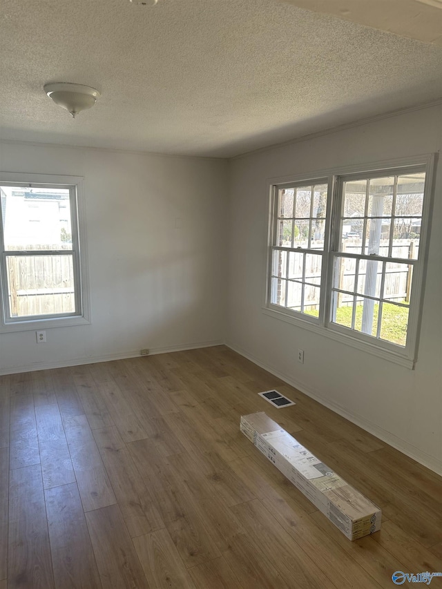 spare room with wood-type flooring and a textured ceiling