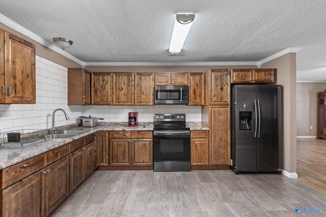 kitchen with brown cabinets, appliances with stainless steel finishes, backsplash, and a sink