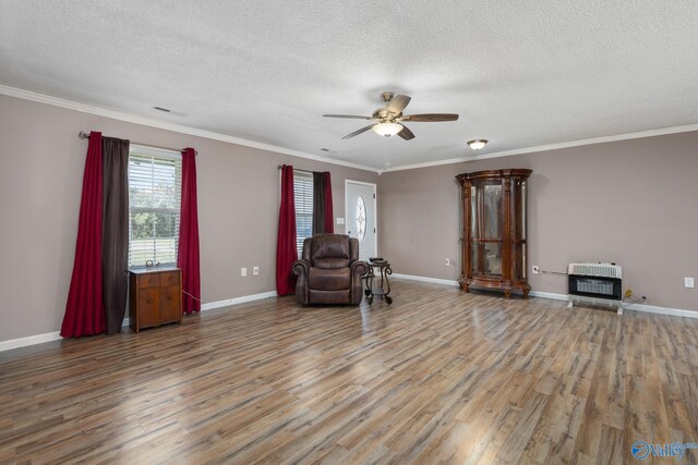 unfurnished room featuring heating unit, baseboards, wood finished floors, and ornamental molding