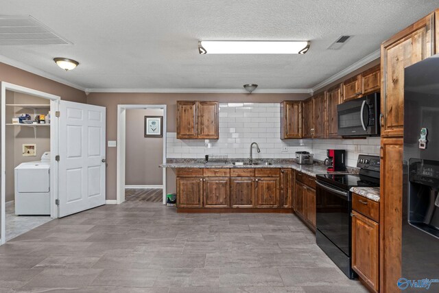 kitchen featuring black electric range, washer / dryer, fridge with ice dispenser, and visible vents