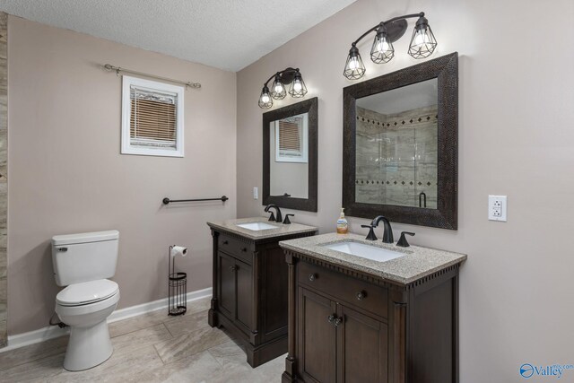 full bath featuring a stall shower, two vanities, a sink, and toilet