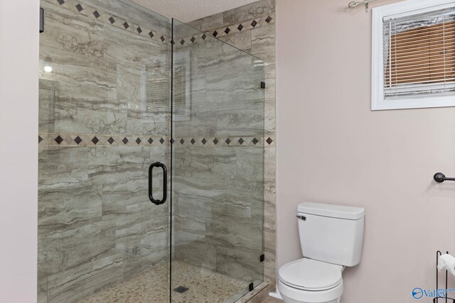 bathroom featuring toilet and a shower stall