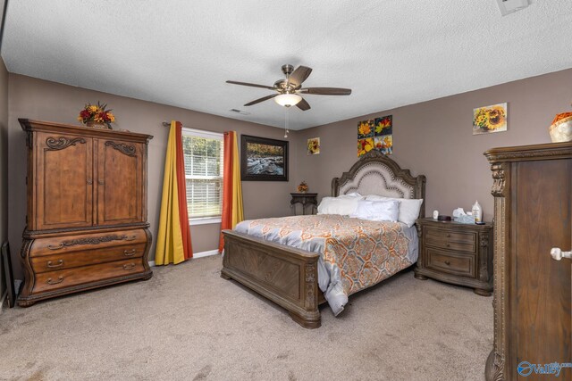 bedroom featuring a textured ceiling, light carpet, visible vents, a ceiling fan, and baseboards