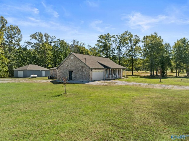 view of side of property featuring a garage, a lawn, and dirt driveway