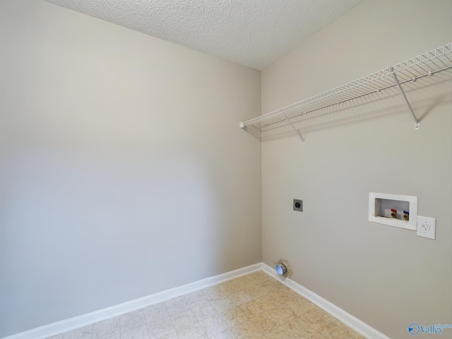 laundry area with hookup for an electric dryer, hookup for a washing machine, and a textured ceiling