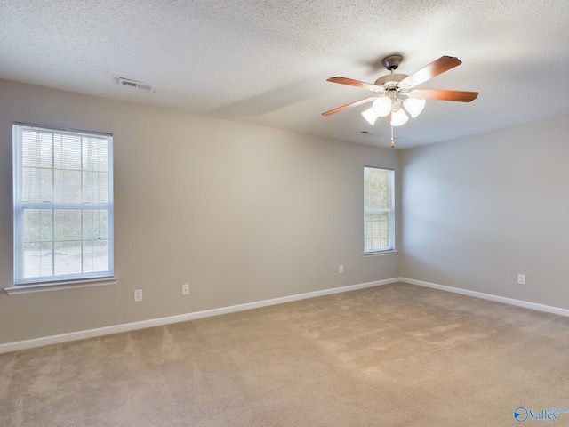 carpeted empty room with ceiling fan and a textured ceiling