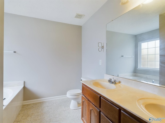 bathroom featuring vanity, toilet, and a tub