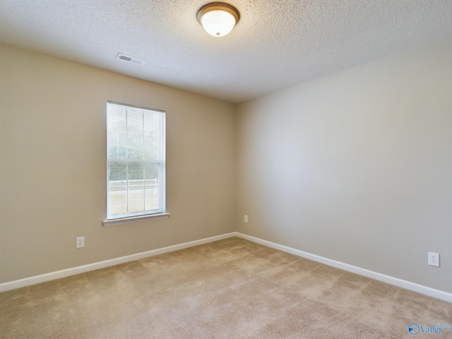 carpeted spare room with a textured ceiling