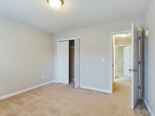 unfurnished bedroom with a textured ceiling, light colored carpet, and a closet