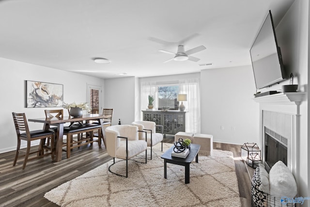 living room featuring ceiling fan and dark hardwood / wood-style floors