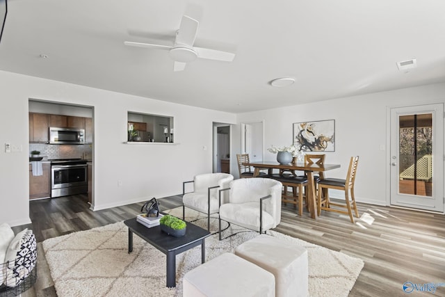 living room with ceiling fan and hardwood / wood-style flooring