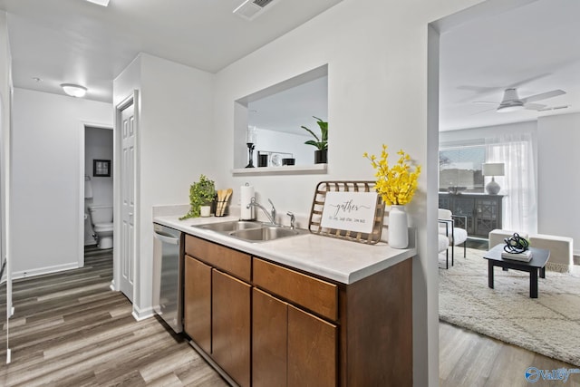 kitchen featuring ceiling fan, sink, dishwasher, and light hardwood / wood-style flooring