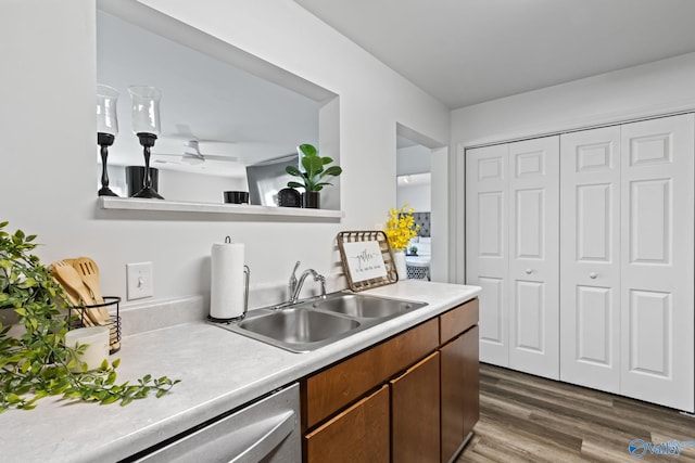 kitchen featuring dark wood-type flooring, ceiling fan, stainless steel dishwasher, and sink