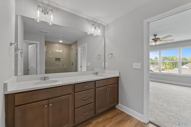 bathroom featuring ceiling fan, vanity, a shower with shower door, and wood-type flooring