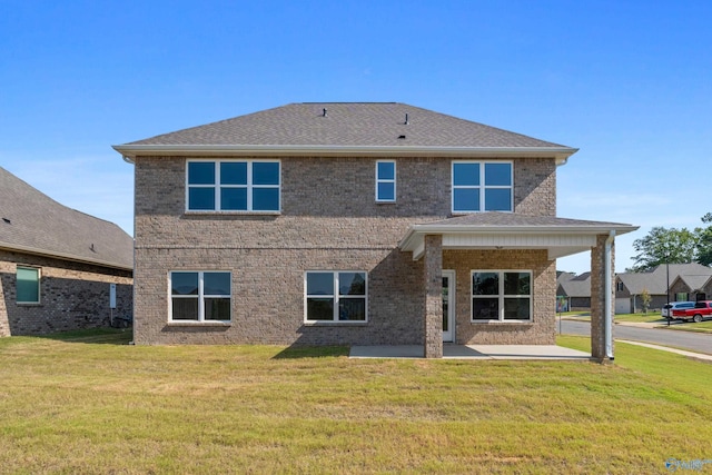 rear view of property featuring a yard and a patio