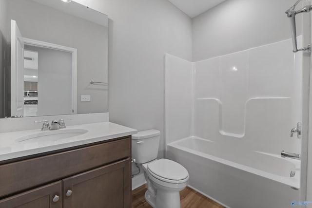 full bathroom featuring vanity, hardwood / wood-style flooring, shower / tub combination, and toilet