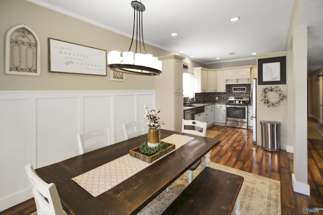 dining space featuring ornamental molding, dark hardwood / wood-style floors, a chandelier, and sink