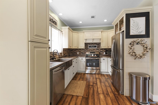 kitchen featuring sink, backsplash, dark wood-type flooring, and stainless steel appliances