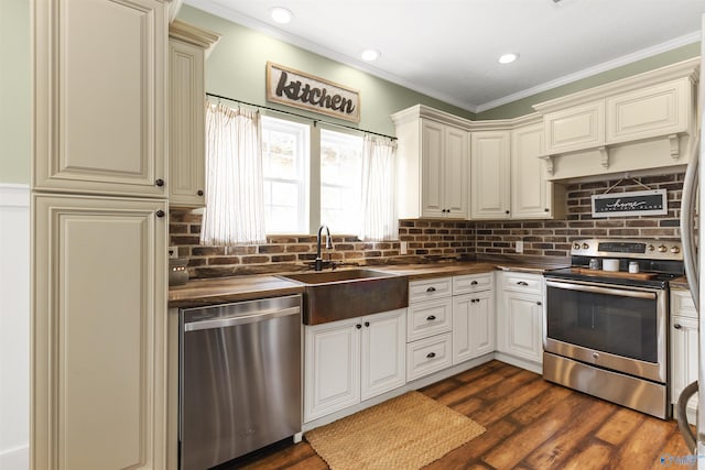 kitchen with sink, crown molding, dark wood-type flooring, appliances with stainless steel finishes, and backsplash