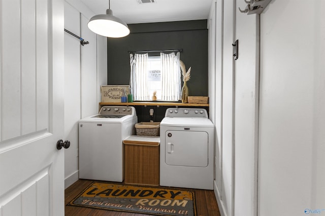 washroom featuring dark hardwood / wood-style flooring and washing machine and clothes dryer