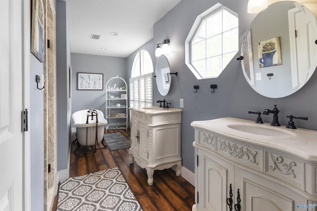 bathroom with vanity, wood-type flooring, and a tub