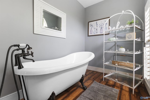 bathroom with a bath and hardwood / wood-style floors