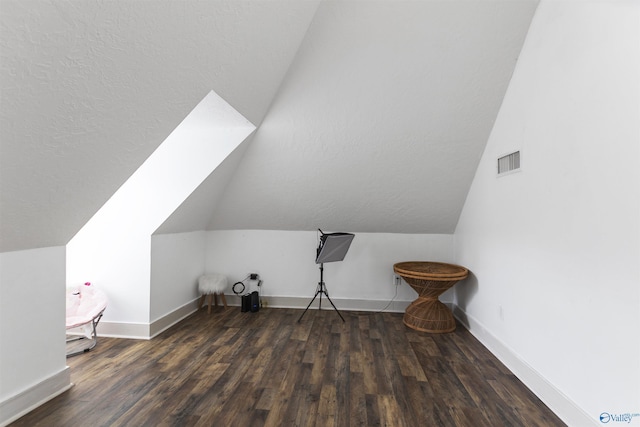 additional living space with lofted ceiling and dark hardwood / wood-style flooring