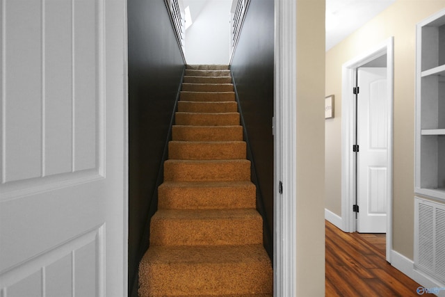 staircase with hardwood / wood-style floors