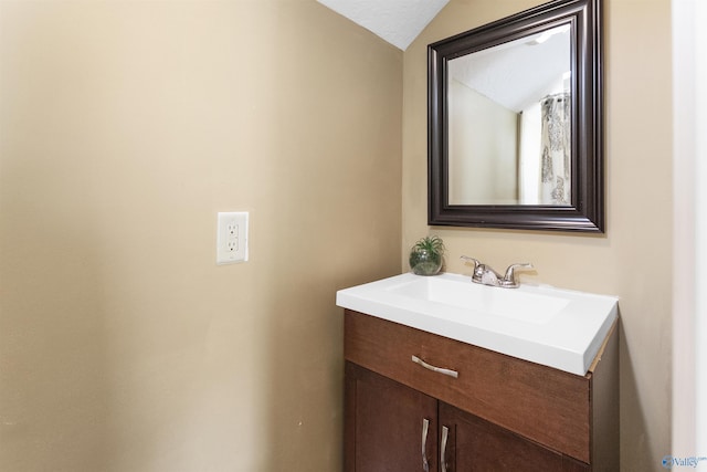 bathroom featuring lofted ceiling and vanity