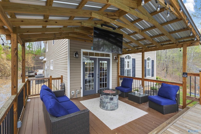 wooden terrace featuring an outdoor living space with a fire pit and french doors